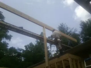 Carpenter setting a ridge beam over a new addition frame — Ice Dam Removal by Roofing Brothers in Narrowsburg