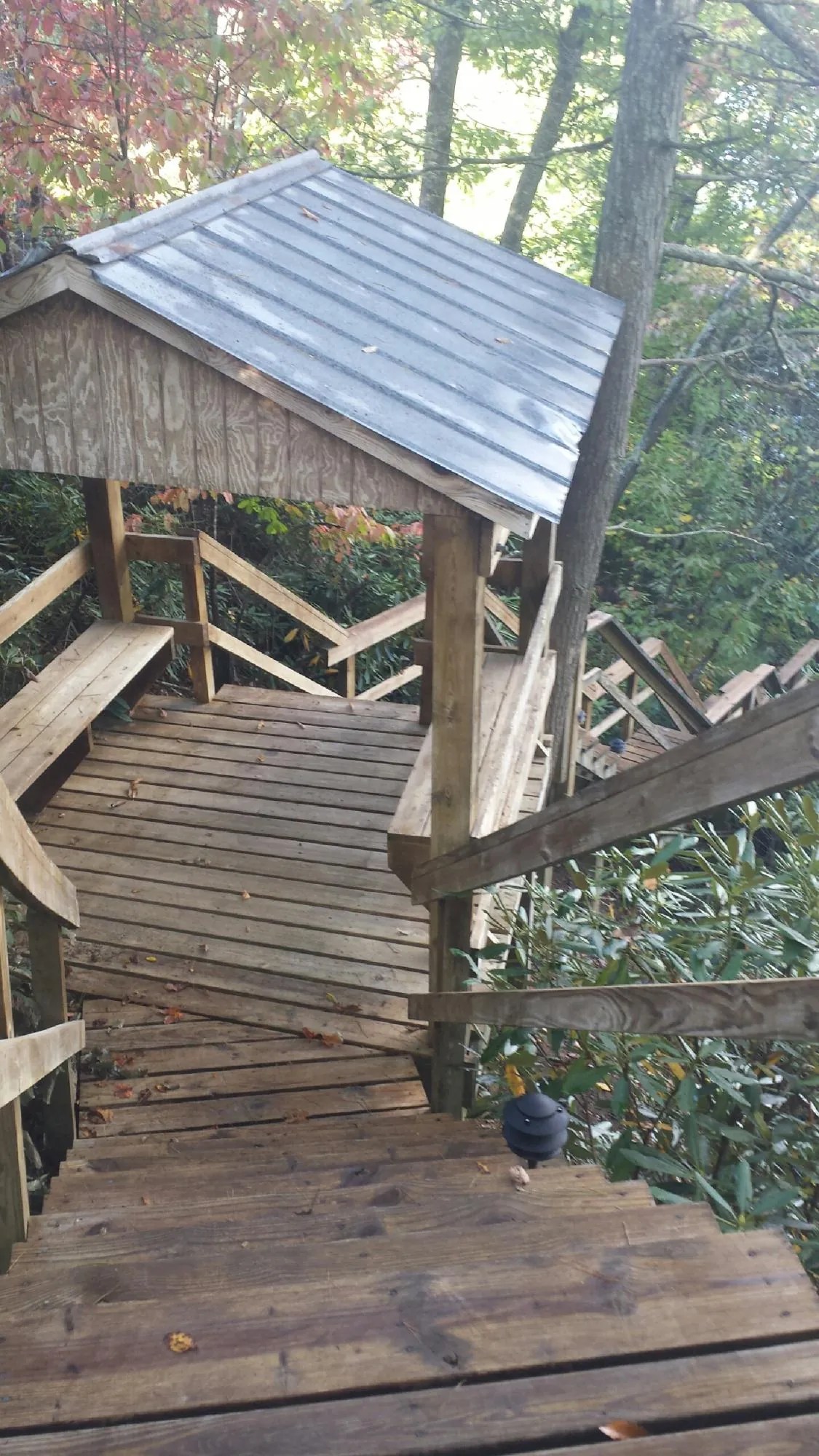 Metal roofed shelter over wooden steps on a wooded walkway — Skylight Repair & Installation work by our crew in Narrowsburg