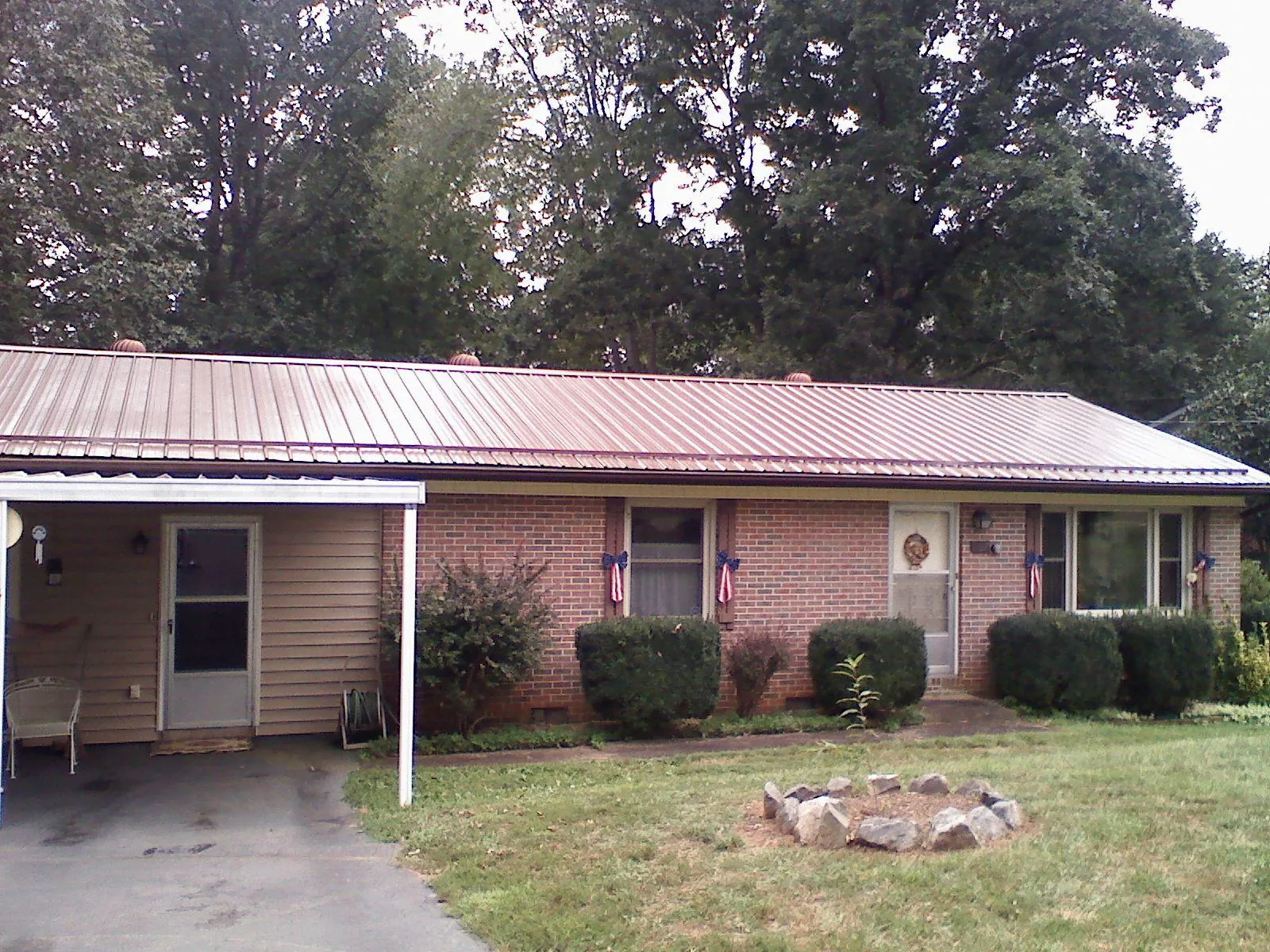 Bronze metal roof and carport on a brick ranch home — Roof Repair work by our crew in Narrowsburg